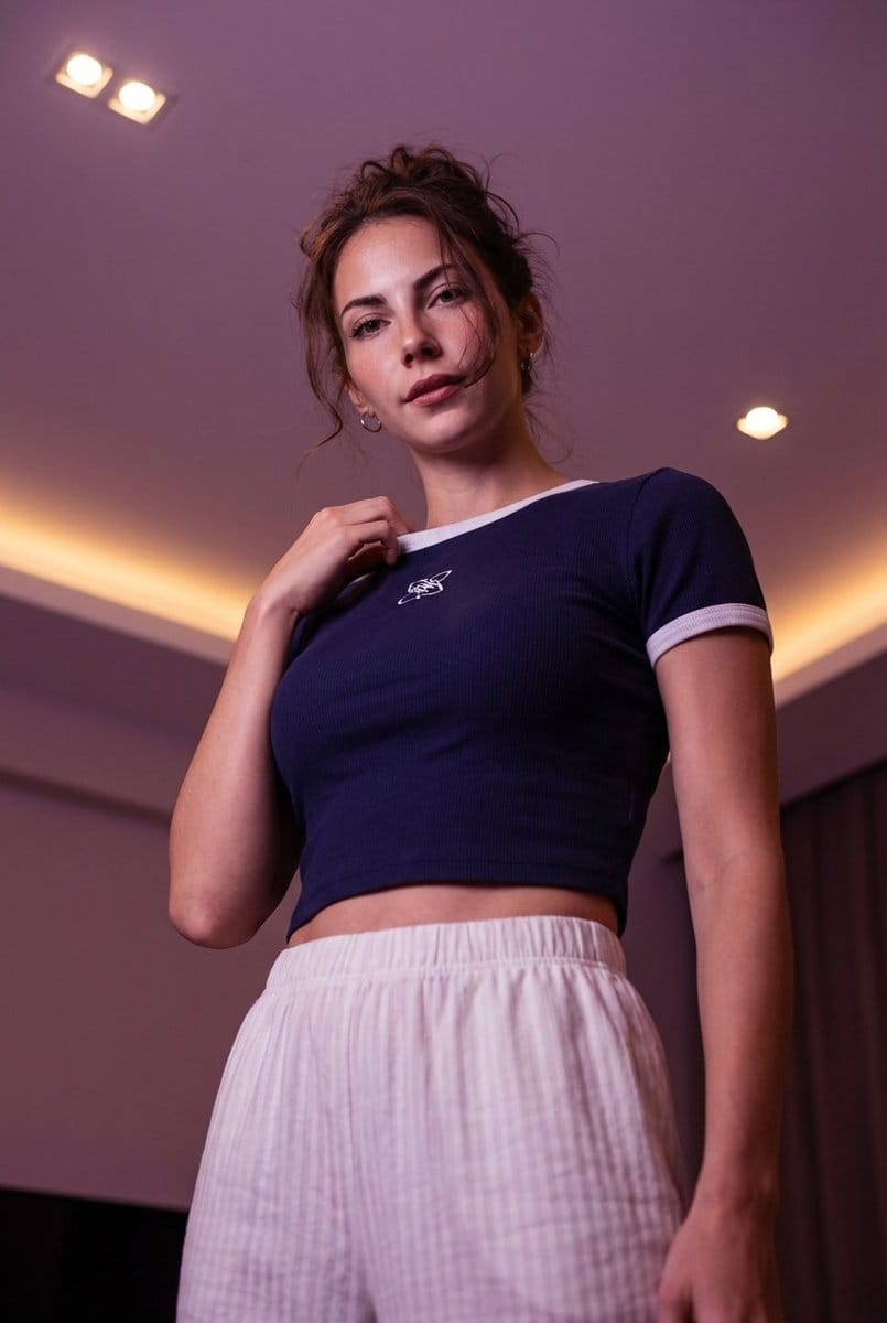 Low-angle stylized portrait of a young woman in a dim room