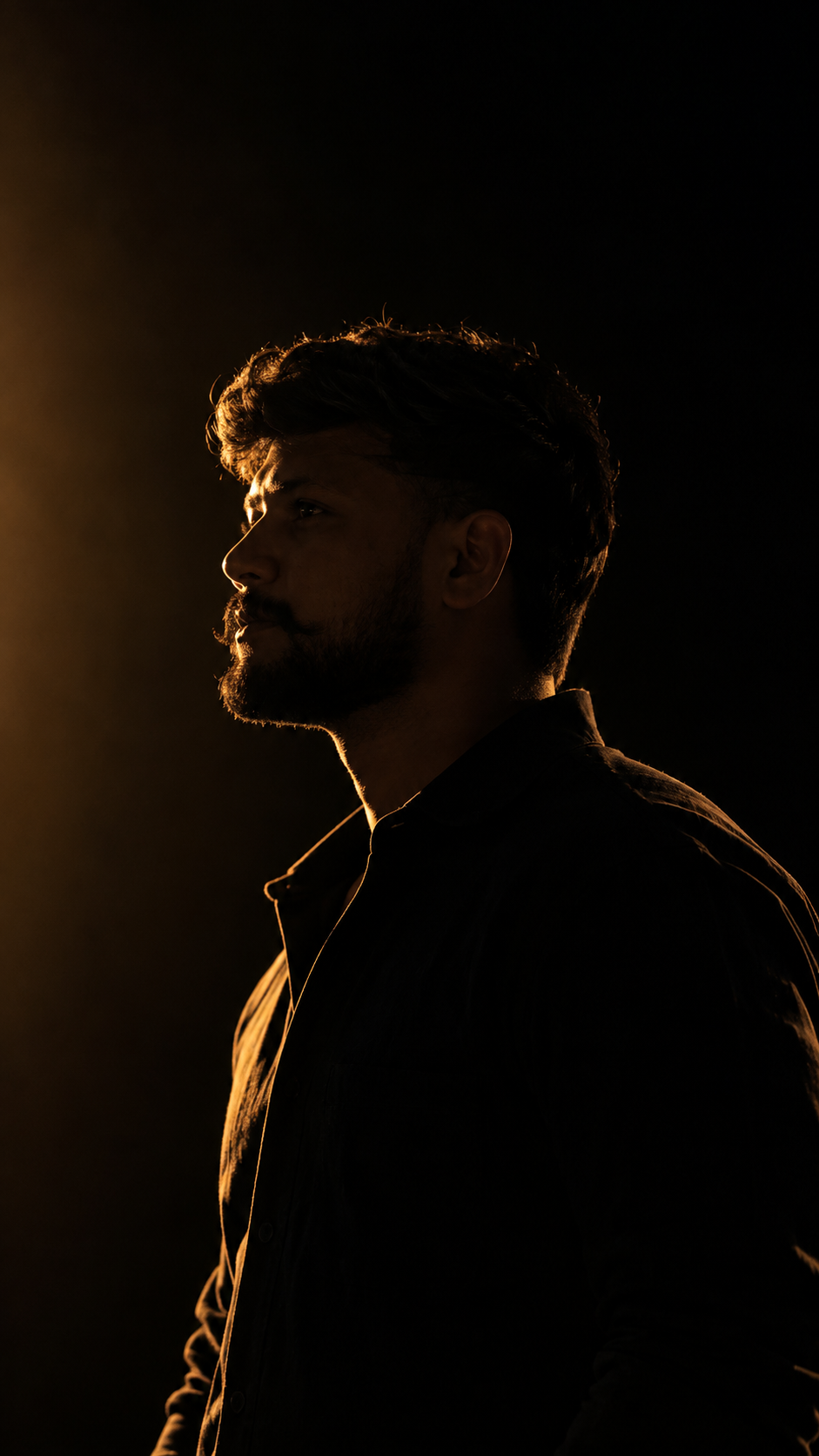 Create a cinematic, ultra-realistic outdoor editorial portrait of a young South Indian man sitting n KI-Anweisungsbeispiel